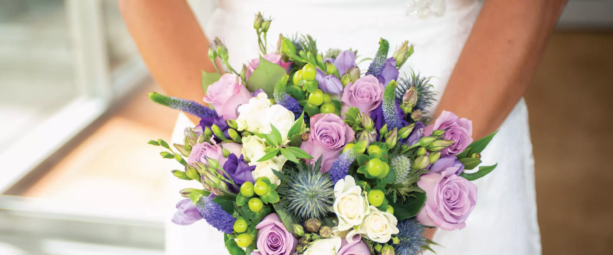 A wedding bouquet made up of white, pink and purple flowers..