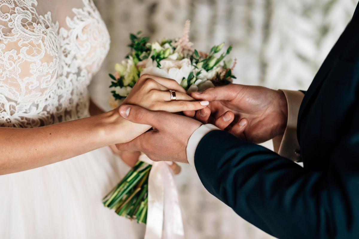 bride and groom placing rings on fingers